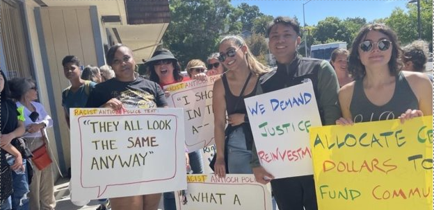 A group of diverse people holding signs demanding justice